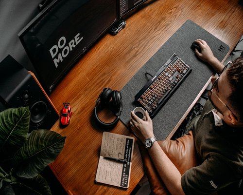 Person working attentively at a comfortable home desk setup